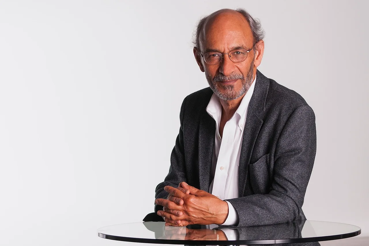 mentor, gray blazer, white shirt, professional, male, corporate portrait, glasses, indian, thin, business executive, consultant, middle-aged, balding, glass table, folding hands, ceo, beard, thinking, ceo, ceo, ceo, ceo, ceo. Which Leadership Influence Metrics Actually Matter in US Companies?