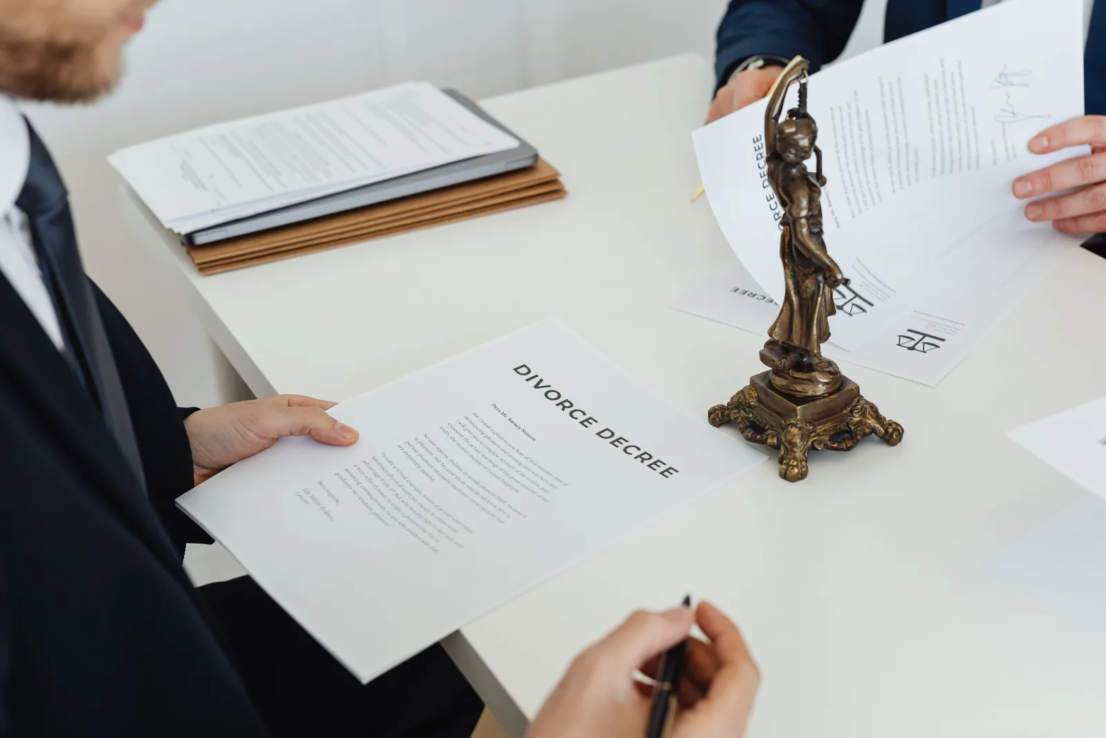 Two professionals discuss divorce decree documents, focusing on legal negotiations. Negotiation ethics: what you may keep silent and what you may not say